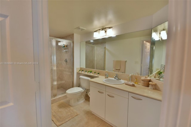 bathroom with vanity, toilet, tile patterned floors, and a shower with shower door