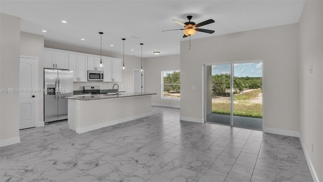 kitchen featuring light tile patterned flooring, ceiling fan, stainless steel appliances, white cabinets, and a kitchen island with sink