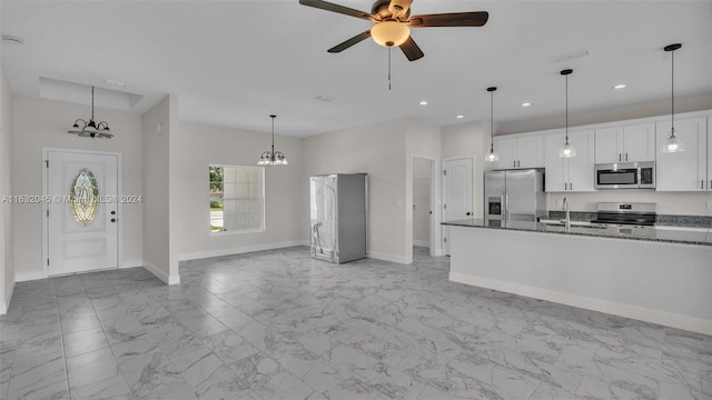 kitchen with white cabinetry, light tile patterned floors, ceiling fan with notable chandelier, appliances with stainless steel finishes, and sink