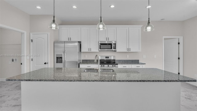 kitchen featuring a kitchen island with sink, white cabinetry, and stainless steel appliances