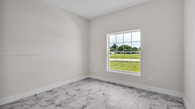 tiled empty room featuring a wealth of natural light