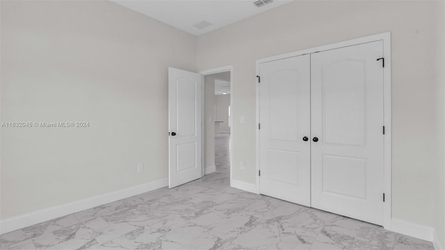 unfurnished bedroom featuring light tile patterned flooring and a closet