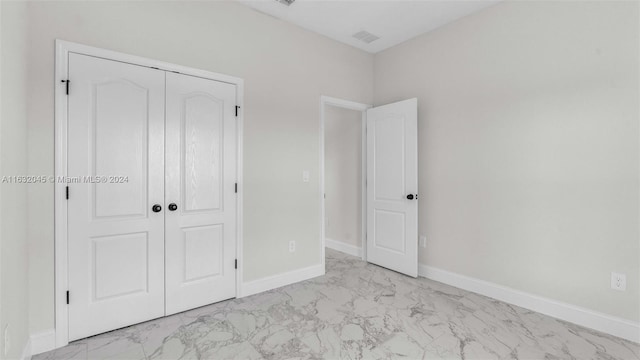 unfurnished bedroom featuring light tile patterned flooring and a closet