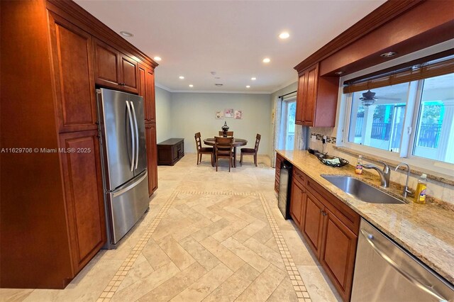 kitchen with sink, crown molding, appliances with stainless steel finishes, beverage cooler, and light stone countertops