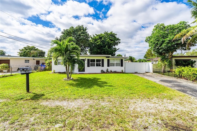 single story home with a front lawn, fence, driveway, and stucco siding