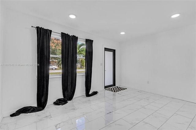 spare room with recessed lighting and marble finish floor