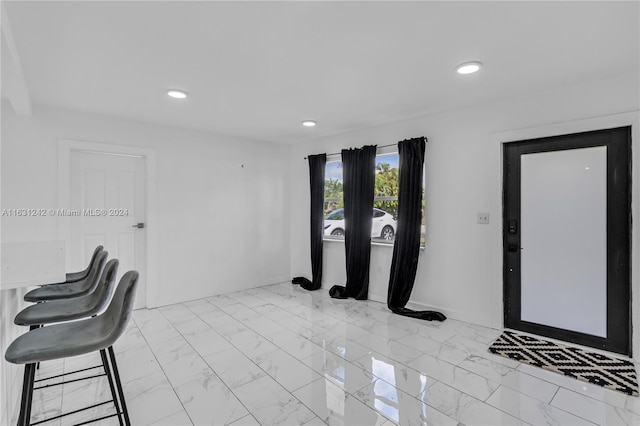 entrance foyer featuring recessed lighting, marble finish floor, and baseboards