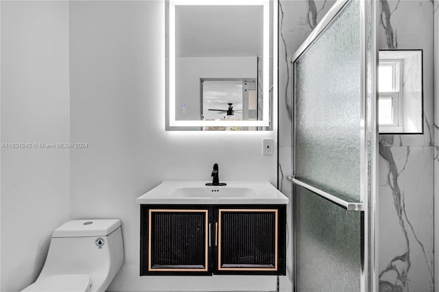 bathroom featuring vanity, a shower stall, and toilet