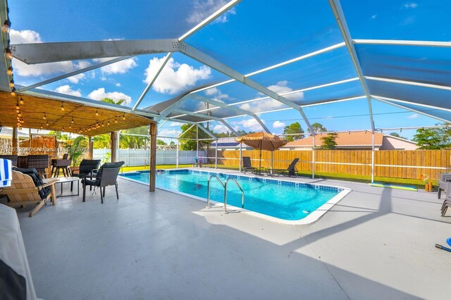 view of swimming pool with a patio and glass enclosure