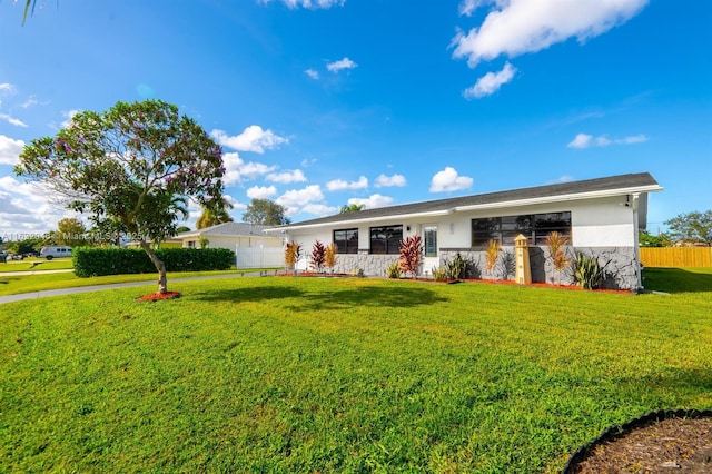 ranch-style house with stucco siding, fence, and a front yard