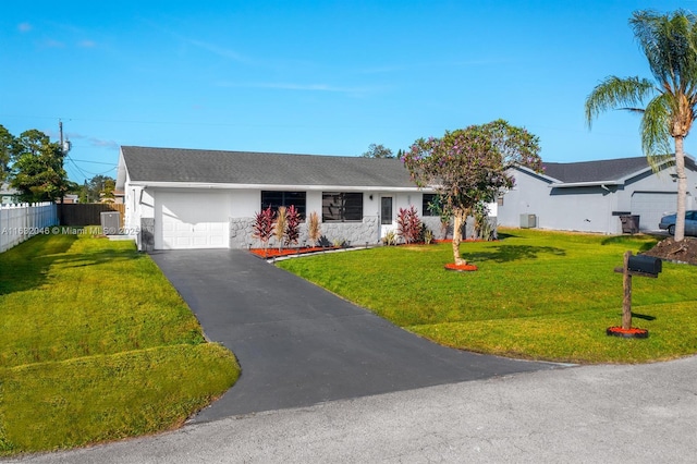 ranch-style house with driveway, a garage, fence, a front lawn, and stucco siding