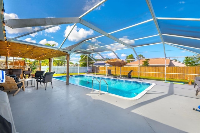 view of pool with a fenced in pool, glass enclosure, a fenced backyard, and a patio