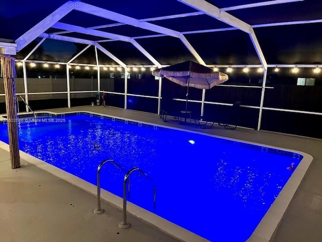 pool at twilight featuring a fenced in pool, a lanai, and a patio area