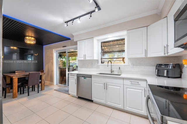 kitchen with light tile patterned flooring, stainless steel appliances, a sink, decorative backsplash, and crown molding