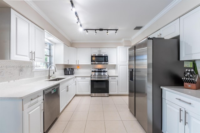 kitchen with white cabinetry, rail lighting, appliances with stainless steel finishes, decorative backsplash, and sink