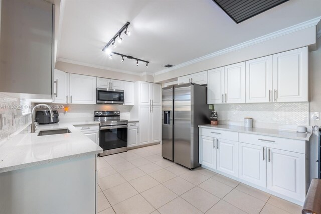 kitchen featuring decorative backsplash, stainless steel appliances, track lighting, and white cabinets