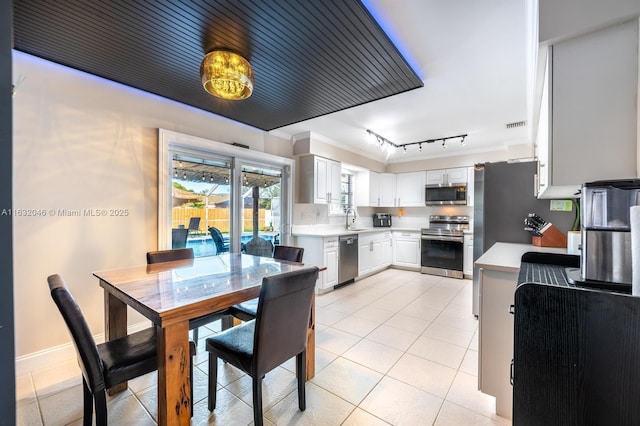 dining area featuring rail lighting, visible vents, crown molding, and light tile patterned flooring