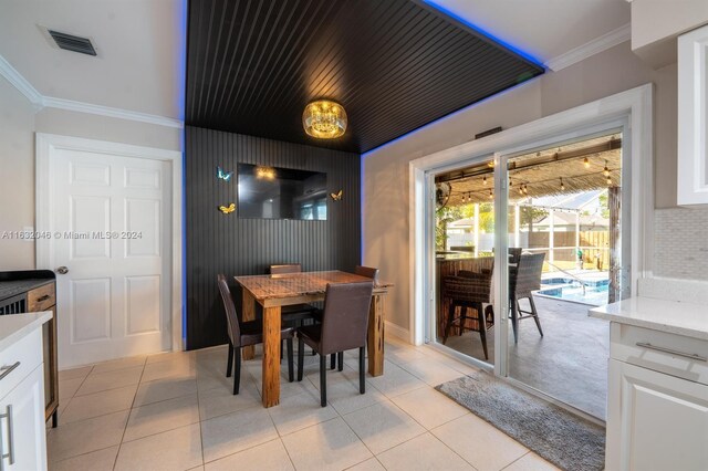 tiled dining space featuring crown molding