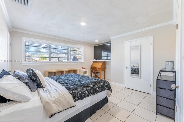 bedroom with ornamental molding and light tile patterned floors