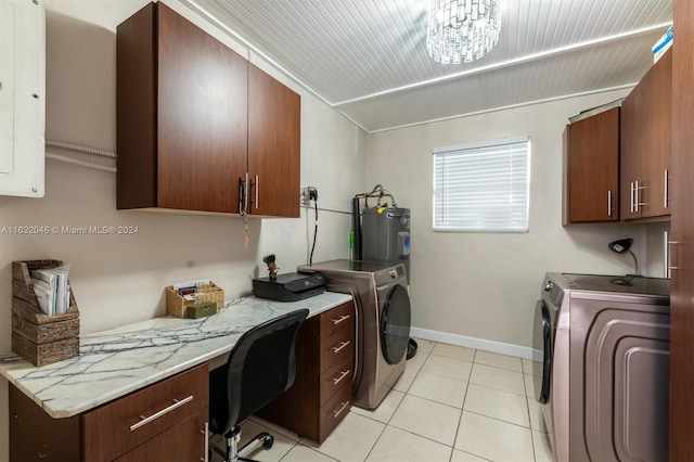 clothes washing area featuring washer and clothes dryer, a chandelier, water heater, and cabinets