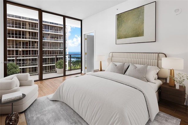 bedroom with access to outside, light hardwood / wood-style flooring, and floor to ceiling windows