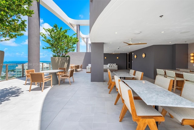 view of patio / terrace featuring a bar, an outdoor hangout area, a water view, and ceiling fan