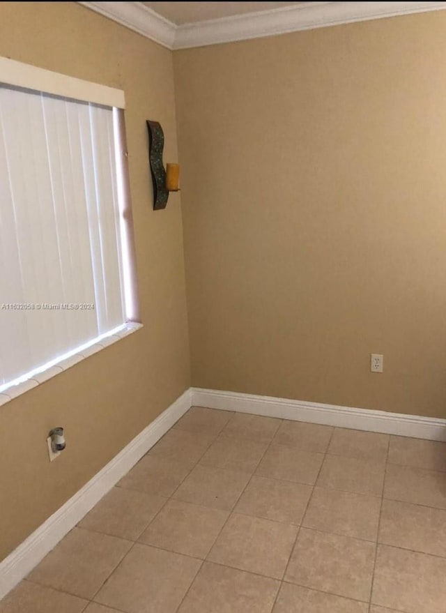 tiled spare room with crown molding