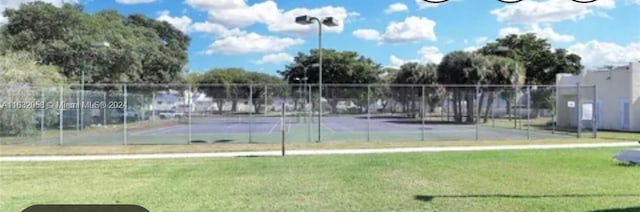 view of sport court with a yard