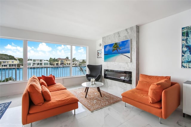 living room featuring a wealth of natural light, a water view, and a fireplace