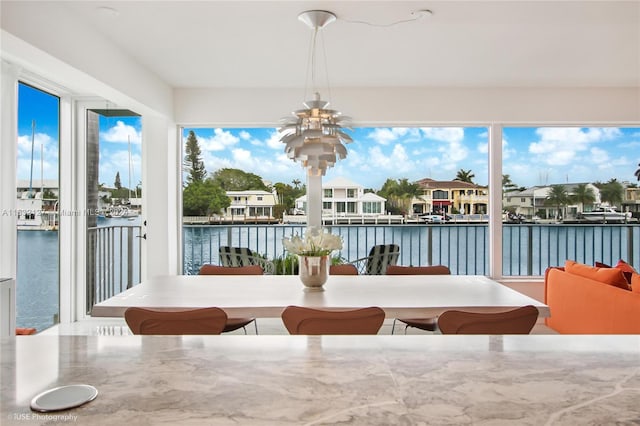 sunroom / solarium featuring a water view