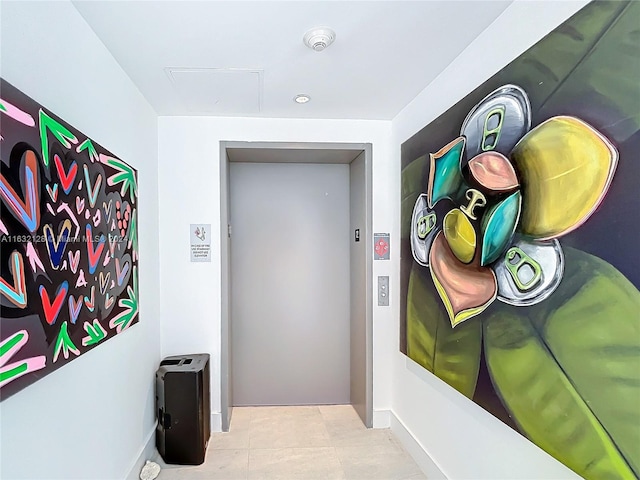 hall featuring elevator and light tile patterned floors