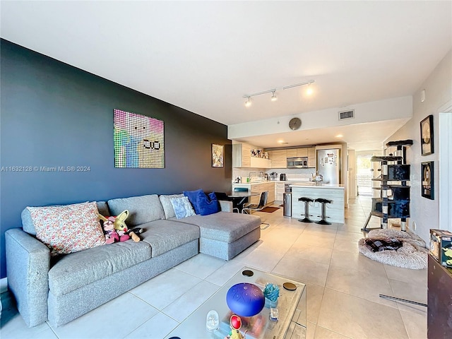 living room with track lighting and light tile patterned floors