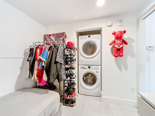 laundry area featuring stacked washing maching and dryer and light tile patterned floors