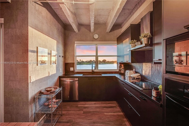 kitchen featuring dark wood-type flooring, black appliances, sink, wall chimney exhaust hood, and beam ceiling