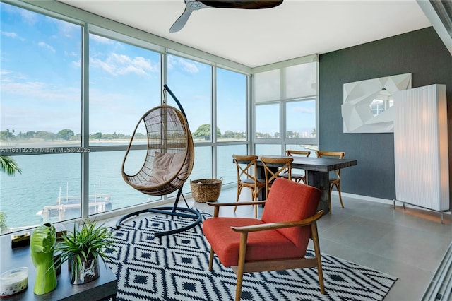 sunroom / solarium with a water view, a wealth of natural light, and ceiling fan