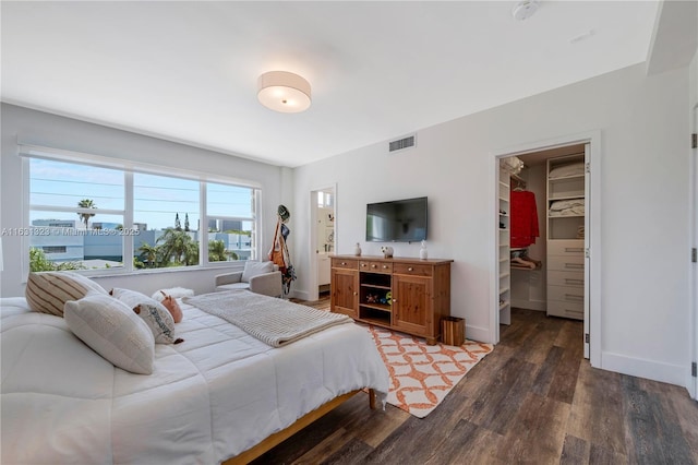 bedroom featuring dark hardwood / wood-style flooring, a walk in closet, and a closet