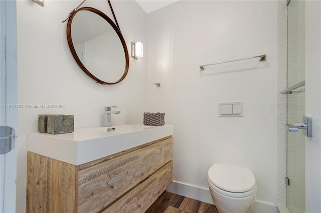 bathroom featuring wood-type flooring, vanity, and toilet