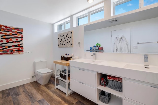 bathroom featuring toilet, vanity, and hardwood / wood-style flooring