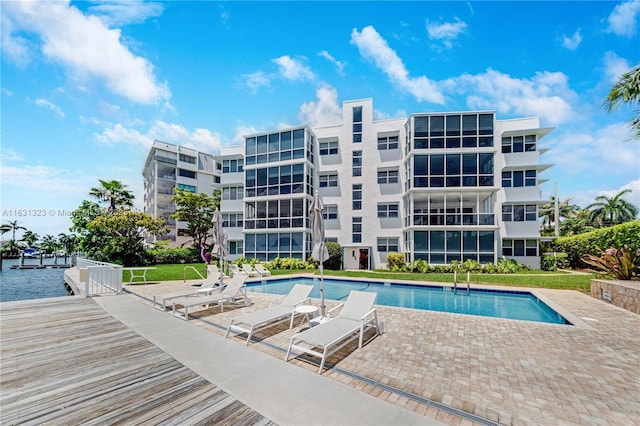 view of swimming pool featuring a patio area and a water view