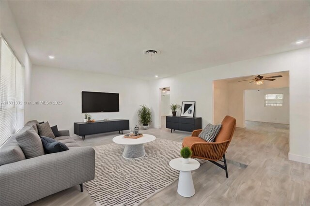 living room with ceiling fan and light hardwood / wood-style flooring