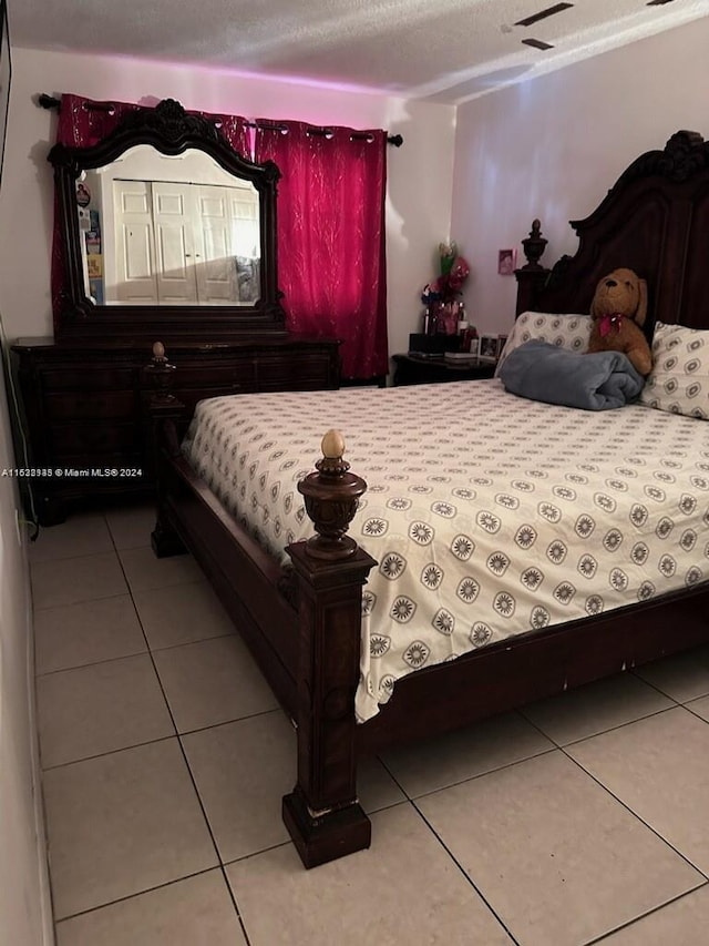 tiled bedroom featuring a textured ceiling