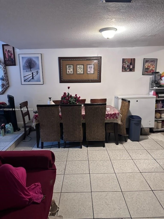 tiled dining area featuring a textured ceiling