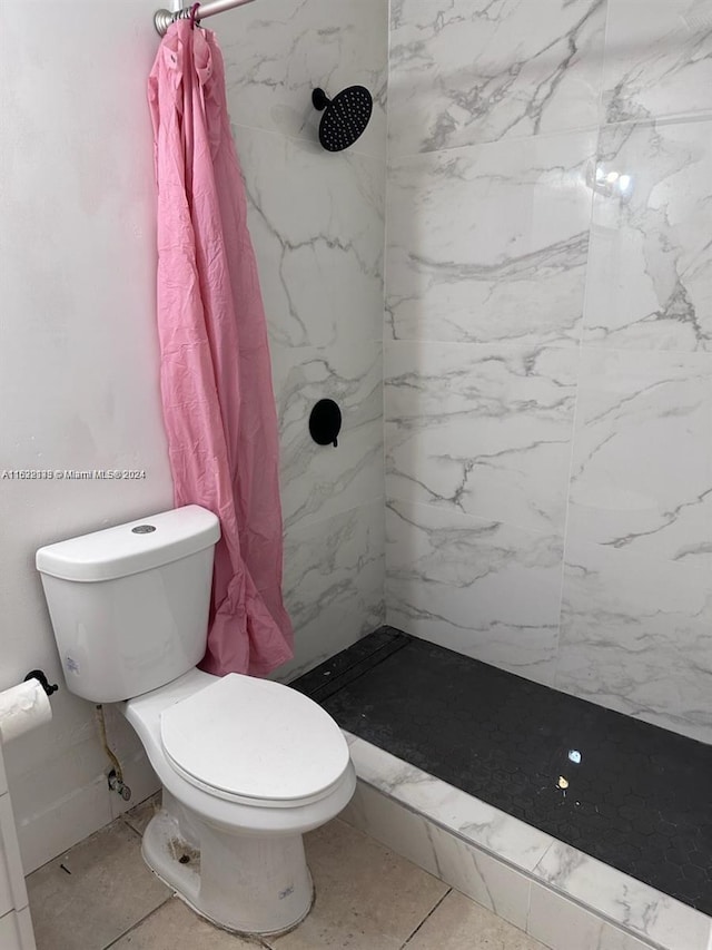 bathroom with toilet, tile patterned floors, and a shower with shower curtain