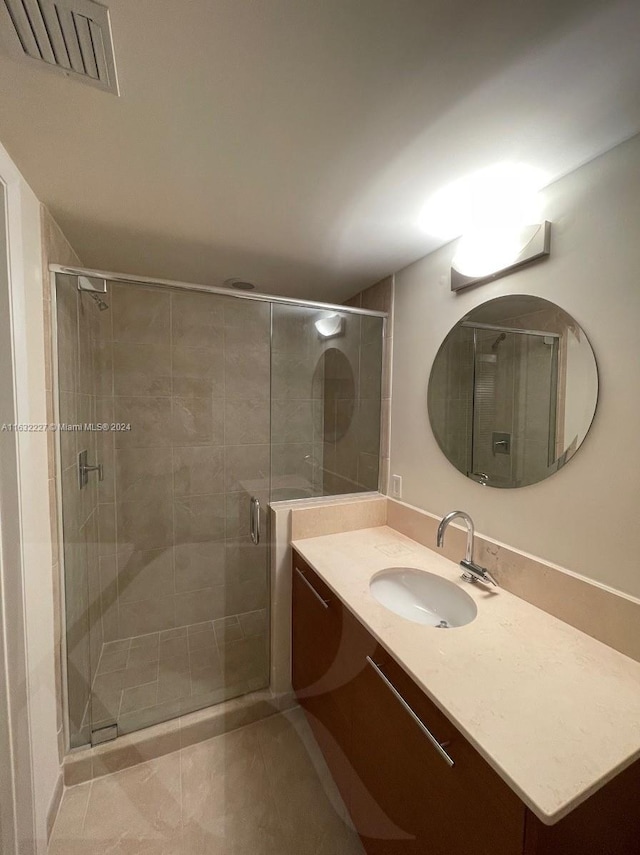 bathroom with vanity, an enclosed shower, and tile patterned floors