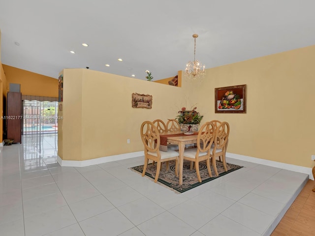 dining room with an inviting chandelier, lofted ceiling, and light tile patterned floors