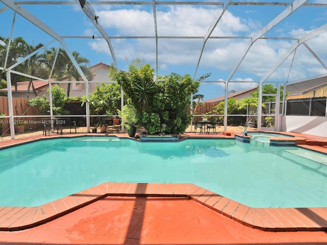 view of pool with a patio, an in ground hot tub, and a lanai