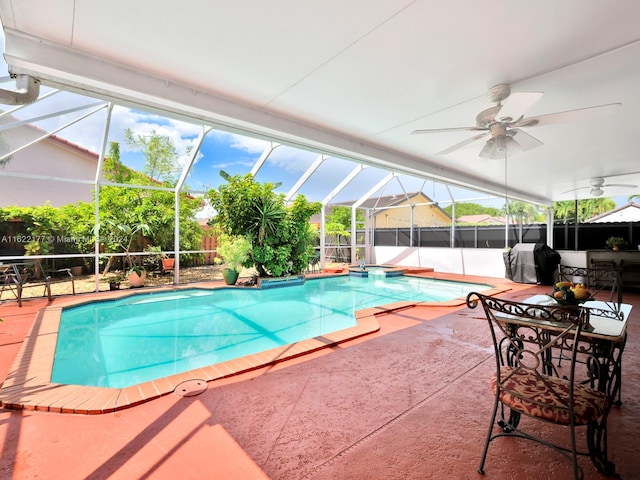 view of pool with area for grilling, a patio, ceiling fan, and glass enclosure