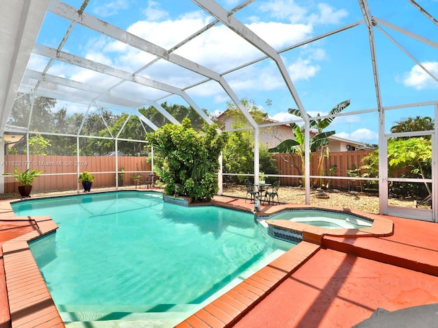 view of pool with an in ground hot tub and glass enclosure