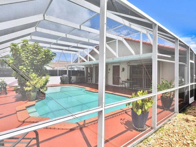 view of pool featuring a patio, ceiling fan, and glass enclosure