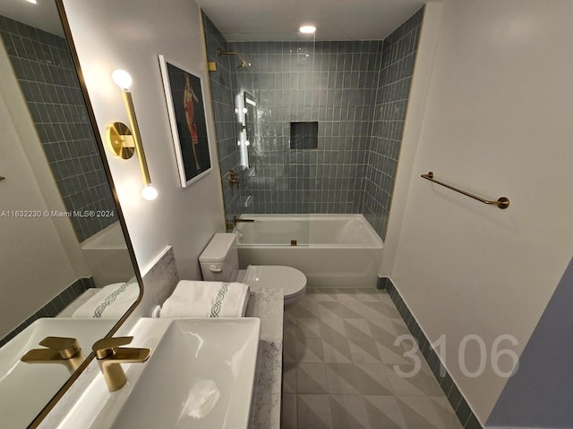 bathroom with tiled shower / bath combo, toilet, and tile patterned flooring